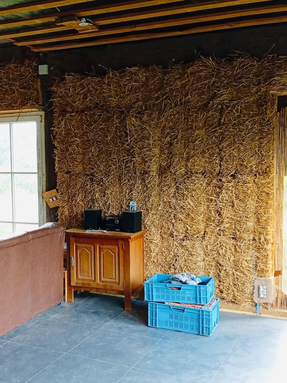 Mur en bottes de paille dans un séjour en rénovation